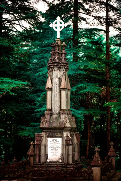 Historic Tomb of James Bruce surrounded by lush deodar forests in Dharamshala, Himachal Pradesh, a colonial-era landmark featured in Himachal Pradesh tour packages.