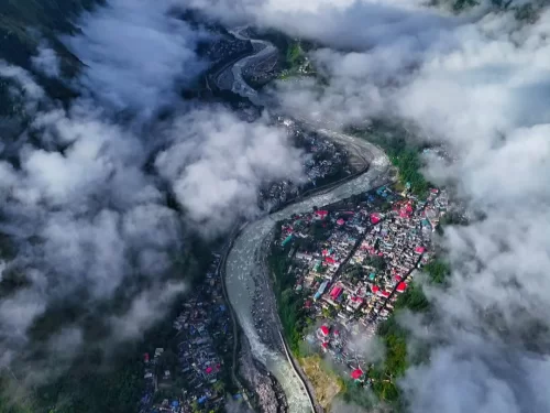 Dharchula aerial view with river valley, clouds and Himalayan town landscape in Uttarakhand tour packages.