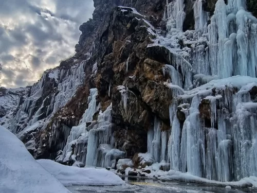 Drung Waterfall Tangmarg frozen waterfall with dramatic icicles and snow-covered cliffs in Gulmarg Kashmir