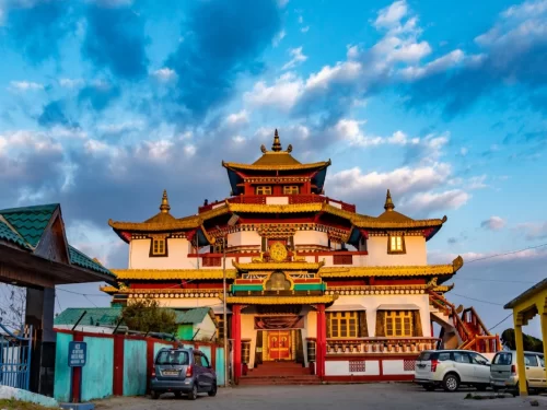 Durpin Monastery in Kalimpong, West Bengal, showcasing vibrant Tibetan-style architecture with ornate golden roofs against a dramatic sky, a prominent Buddhist site included in West Bengal tour packages.