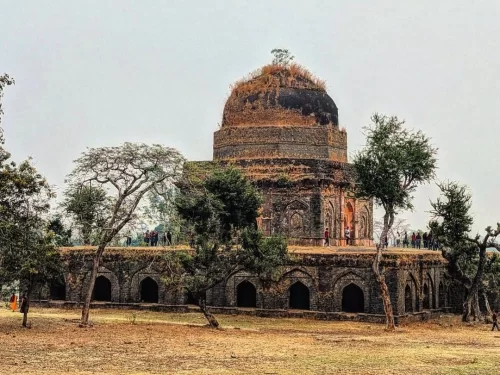 Historic stone pavilion at Echo Point in Mandu, Madhya Pradesh, surrounded by open grounds and arched architecture, a scenic heritage site often included in Madhya Pradesh tour packages
