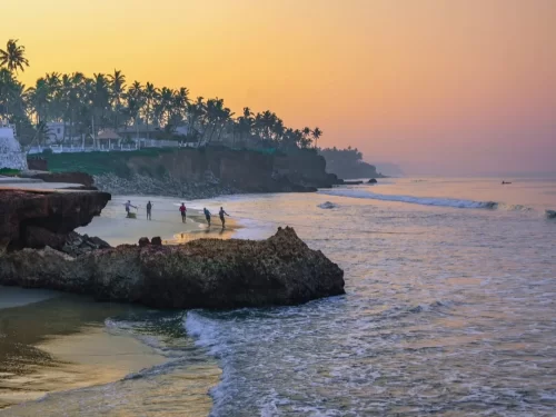 Edava Beach, Kerala sunset view with rocky cliffs, palm trees, golden sand and Arabian Sea waves