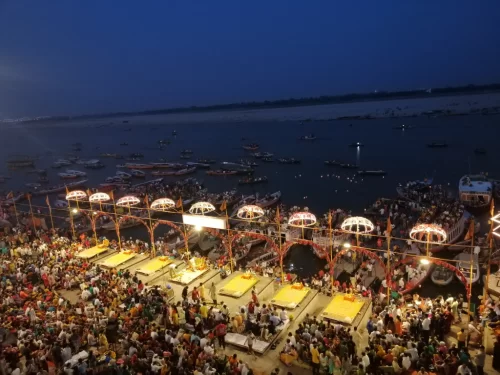 Ganga Aarti at Varanasi ghats during night, featuring lamps crowds boats river views, perfect spiritual Uttar Pradesh tour package.
