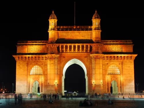 Gateway of India night view beautifully illuminated in golden lights against a black sky, highlighting Mumbai’s iconic waterfront monument and popular evening sightseeing spot in Maharashtra