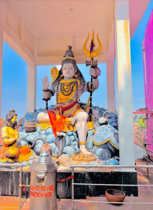 Large statue of Lord Shiva in Puri Odisha with trishul and temple setting under clear sky featured in Odisha tour packages