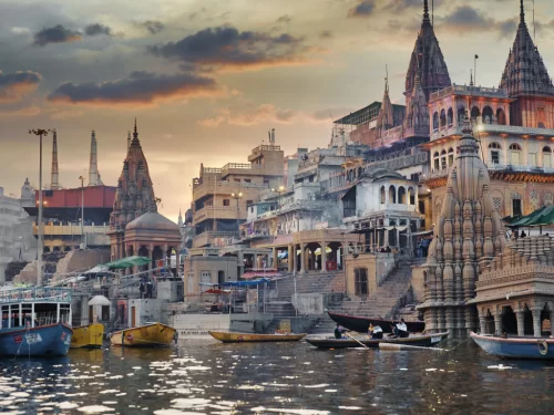Dashashwamedh Ghat at Varanasi during twilight, featuring temples boats spires reflections, perfect spiritual Uttar Pradesh tour package.