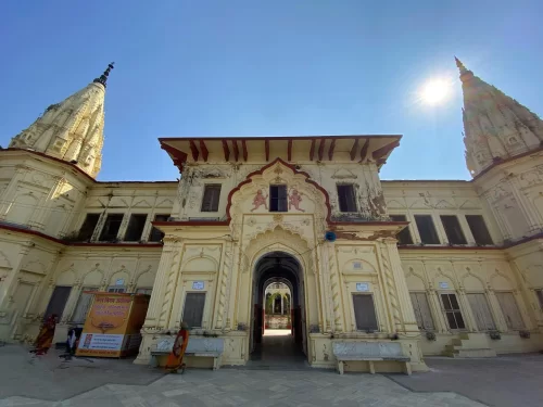 Temple view at Guptar Ghat Ayodhya during sunny day, featuring twin shikharas and ornate arches, perfect cultural experience Uttar Pradesh Tour Packages.