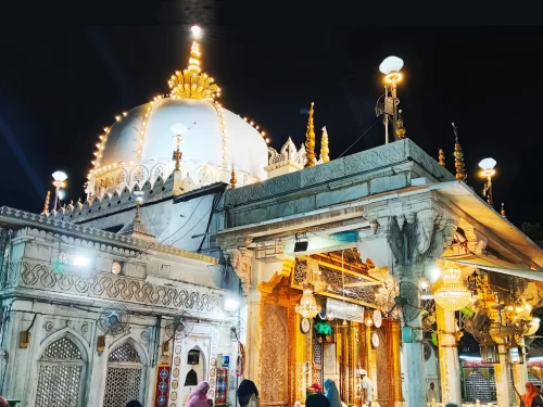 Haji Ali Dargah Mumbai night view featuring illuminated white dome and golden minarets, perfect Mumbai spiritual heritage tour package.