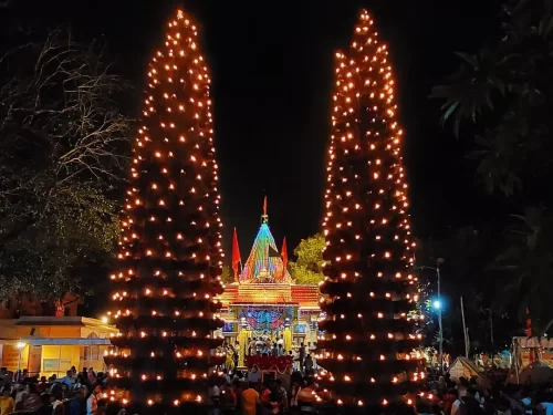 Harsiddhi Mata Temple in Madhya Pradesh with iconic twin deep stambh (lamp towers) and vibrant temple courtyard, a major pilgrimage site often included in Madhya Pradesh tour packages.