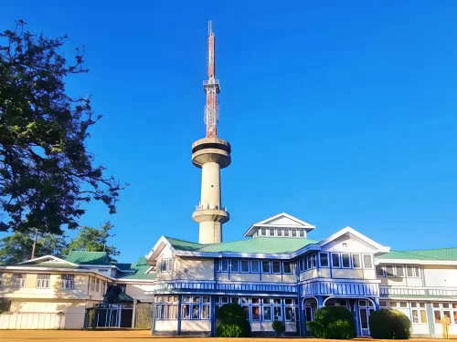 Himachal State Museum Shimla colonial Victorian building with tall TV transmission tower, green lawns trees blue sky, perfect heritage culture spot, Himachal Pradesh tour packages.