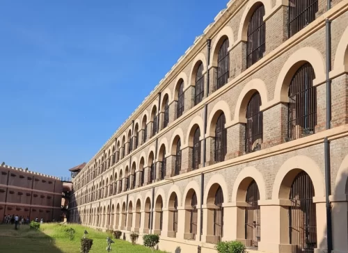 Cellular Jail at Port Blair Andaman Nicobar Islands during clear skies, featuring arched wings, iron bars, watchtowers, gardens, perfect heritage experience Andaman tour package. 
