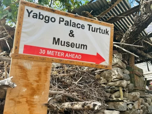 Yabgo Palace and Museum signboard in Turtuk village Nubra Valley Ladakh during sunny day, featuring 30m ahead arrow, stone wall, perfect heritage Turtuk tour package. 