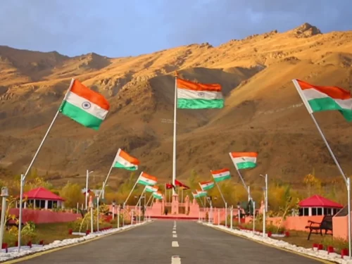 Drass War Memorial Ladakh Indian flags fluttering mountain backdrop pink pavilions pathway gardens patriotic monument Kargil War heroes, perfect Ladakh heritage tour package. ​