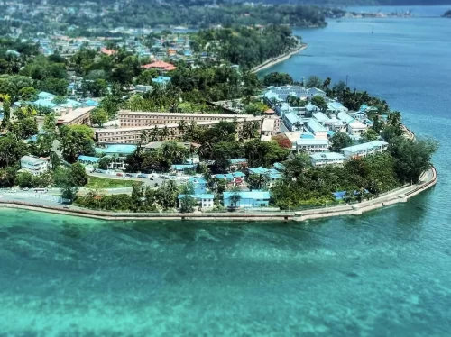 Aerial view of Cellular Jail Port Blair Andaman Nicobar Islands during clear skies, featuring radial wings, surrounding buildings, coastal shoreline, perfect heritage experience Andaman tour package.