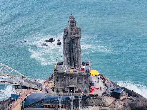 Thiruvalluvar Statue pedestal at Kanyakumari during sunny day, featuring turquoise sea waves and visitors, perfect Kanyakumari tour package