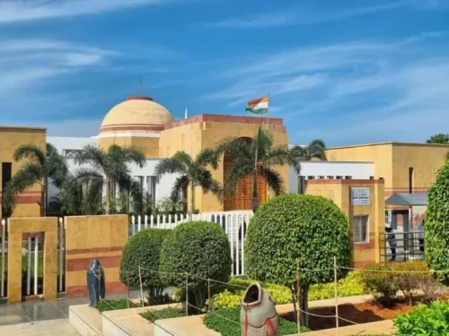 Dr. A.P.J. Abdul Kalam Memorial Pei Karumbu Rameswaram Tamil Nadu India terracotta beige dome building Indian tricolor flag palm trees manicured hedges statue foreground terracotta pot landscaping white fence sunny blue skies, perfect missile man heritage
