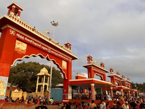 Agni Teertham Rameshwaram Tamil Nadu red Tamil arch gateway devotees temple entrance cloudy sky trees, perfect South India temple pilgrimage tour package. 