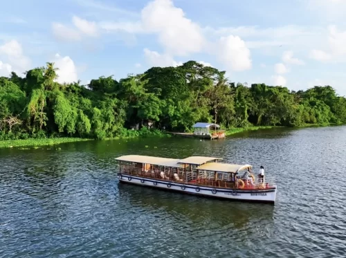 Pathiramanal Island houseboat cruise Vembanad Lake Kerala white canopy boat mangroves huts blue waters clouds, perfect backwaters eco tourism package.