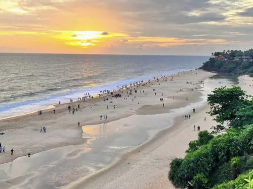 Varkala Beach Kerala cliff top sunset golden sands Arabian Sea, vibrant orange sun crowds palm trees waves, perfect Kerala Papanasam horizon beach package.