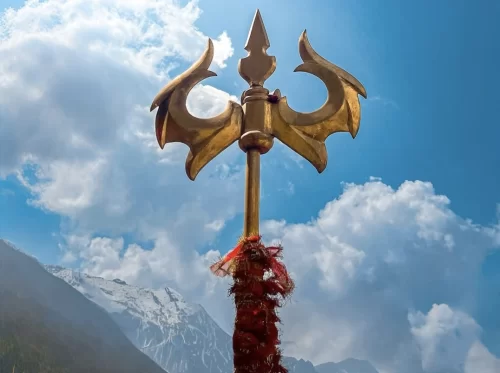Kedarnath temple Uttarakhand golden Trishul trident red sacred threads snowy Himalayan peaks blue cloudy sky, perfect Char Dham Yatra tour packages.