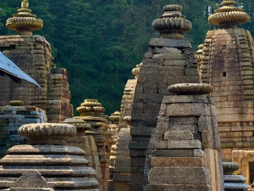 Jageshwar Temple at Almora during sunny day, featuring ancient shikharas, golden kalash, pine forests, perfect spiritual experience Uttarakhand tour packages. 