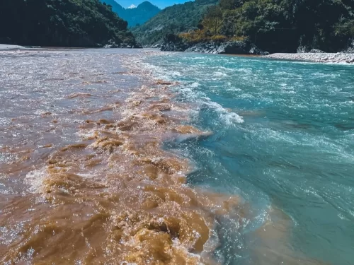 Rudraprayag confluence Alaknanda Mandakini rivers brown turquoise waters merging forested Himalayan gorges mountains, perfect Char Dham Yatra trijunction riverside view, Himachal Pradesh tour packages.