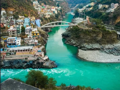 Devprayag Uttarakhand colorful village houses bridge temple green turquoise river rocky gorge forested mountains panoramic view, perfect Uttarakhand tour packages.