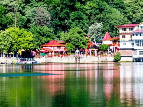 Naina Devi Temple complex along northern shore of Naini Lake Nainital Uttarakhand panoramic view, featuring red-roofed temples amid lush green hills reflected in emerald waters, perfect spiritual heritage landmark hill station tour package.