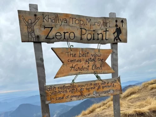 Khaliya Top Munsiyari Zero Point signboard during cloudy weather, featuring trekking info, emergency contact, mountains backdrop, perfect adventure experience, Uttarakhand tour packages.