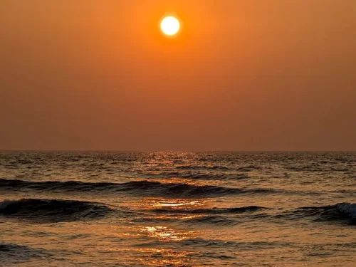 Mobor Beach South Goa perfect orange sunset ball ocean horizon, dark waves golden glow serene waters, perfect Goa tranquil beach sunset package.