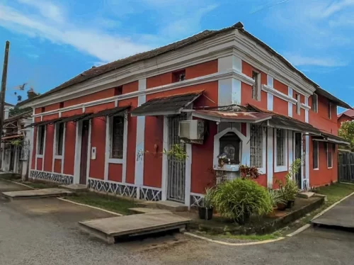 Red and yellow Portuguese style houses in Fontainhas Latin Quarter Panaji Goa, featuring arched windows sunset sky palm accents, perfect heritage experience Goa heritage walking tour package.