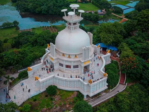 Dhauli Shanti Stupa at Bhubaneswar from aerial view, featuring white dome and lion guardians over Daya River, perfect heritage Bhubaneswar tour package.