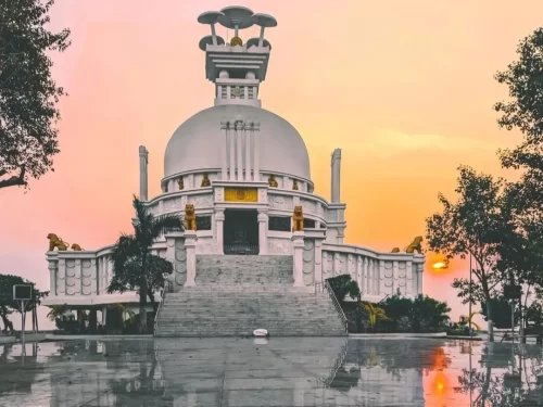 Dhauli Shanti Stupa at Bhubaneswar during sunset, featuring lion statues and white dome reflections, perfect heritage Bhubaneswar tour package.