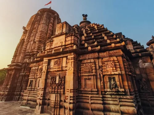 Brahmeswara Temple at Bhubaneswar during golden hour, featuring Odisha flag and Kalinga spires, perfect heritage Bhubaneswar tour package.