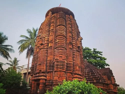 Mukteswara Temple main shikhara at Bhubaneswar during golden hour, featuring Kalinga Nagara deul tower with palm trees, perfect Odisha heritage tour package.