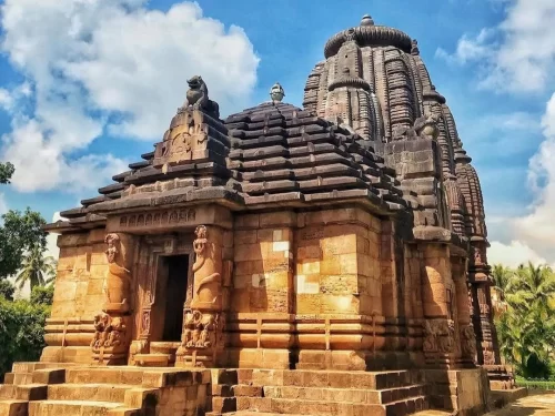 Rajarani Temple Bhubaneswar 11th century Kalinga vimana lion door guardians intricate carvings palms cloudy sky, perfect Odisha heritage temple tour package.