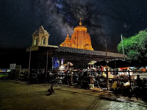 Lingaraj Temple at Bhubaneswar during night with starry sky, featuring illuminated Kalinga spire, perfect heritage Bhubaneswar tour package. 