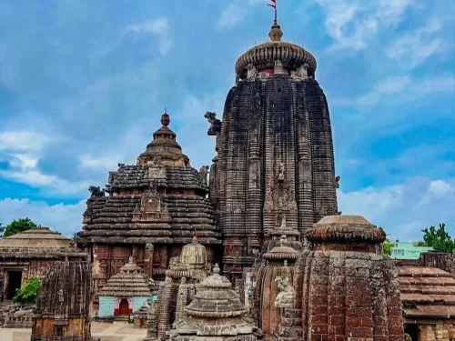 Lingaraj Temple at Bhubaneswar on clear day, featuring main Kalinga spire with Odisha flag, perfect heritage Bhubaneswar tour package.