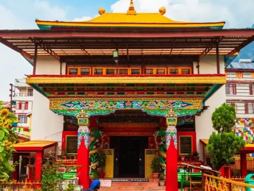 Tsuglagkhang Complex Dalai Lama Temple McLeod Ganj Dharamshala Himachal Pradesh, featuring ornate Tibetan Buddhist architecture golden roofs colorful murals red pillars entrance plants prayer flags backdrop, perfect cultural experience Himachal tour packa