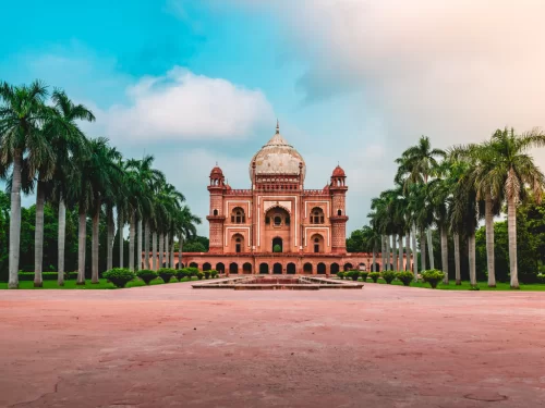 Safdarjung Tomb Delhi with palm-lined garden avenue under blue sky, historic Mughal monument and popular tourist attraction for Delhi tour packages