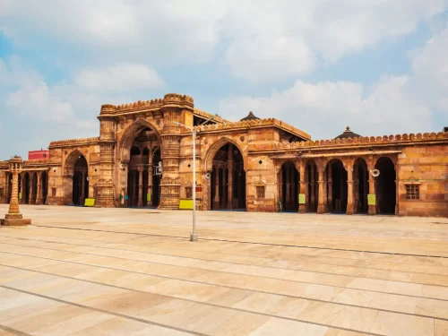 Majestic arches at Jama Masjid Ahmedabad during daylight, featuring sandstone portals and courtyard, perfect cultural Gujarat tour package.