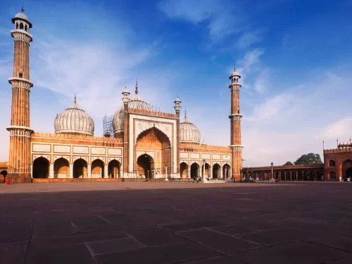Jama Masjid Delhi wide courtyard view with grand Mughal domes and minarets, famous historical mosque and must‑visit attraction in Old Delhi tour packages
