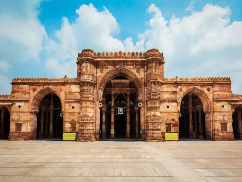 Grand facade at Jama Masjid Ahmedabad during daylight, featuring sandstone arches and minarets, perfect cultural Gujarat tour package.