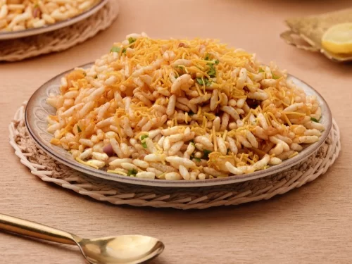 Jhalmuri in tangy spiced puffed rice mix with sev and coriander garnish, authentic Indian street food chaat, crunchy Indian cuisine delight.