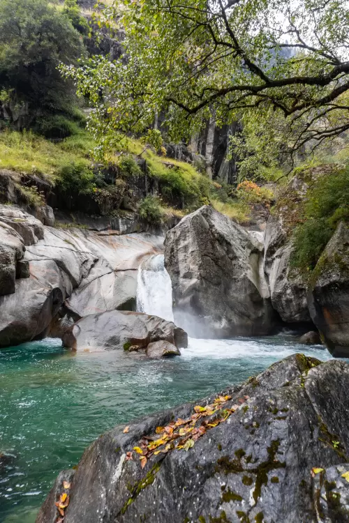 Serene waterfall cascading into a turquoise pool amid lush greenery in Jibhi, Himachal Pradesh, a peaceful offbeat destination featured in Himachal Pradesh tour packages.