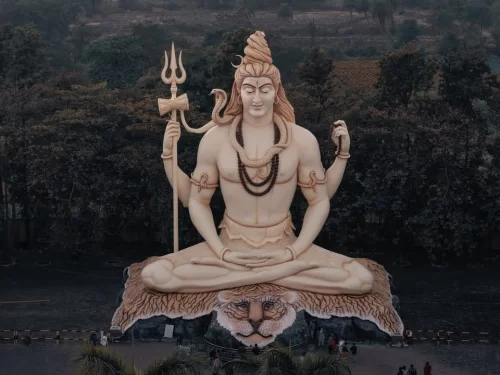 Giant Lord Shiva statue at Kachnar City Shiva Temple in Jabalpur, seated in meditation with trident and tiger-skin base, a prominent spiritual landmark featured in Madhya Pradesh tour packages