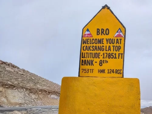BRO milestone Welcome You at Kaksang La Top Altitude 17851 FT Rank – 8th against barren high-altitude mountains under cloudy sky, ideal for Ladakh road trip photogra