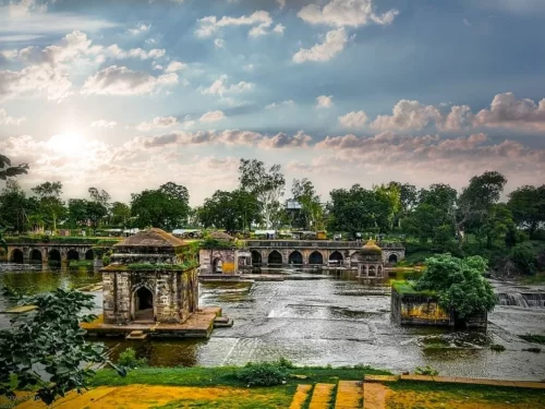 Kaliyadeh Palace in Madhya Pradesh overlooking the Shipra River with arched corridors and historic Mughal-era architecture, a scenic heritage site often included in Madhya Pradesh tour packages.