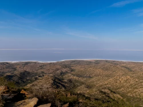 Kalo Dungar viewpoint at Kutch during clear day, featuring Great Rann salt desert panorama, arid hills and endless white expanse, perfect adventure experience with Gujarat tour packages.