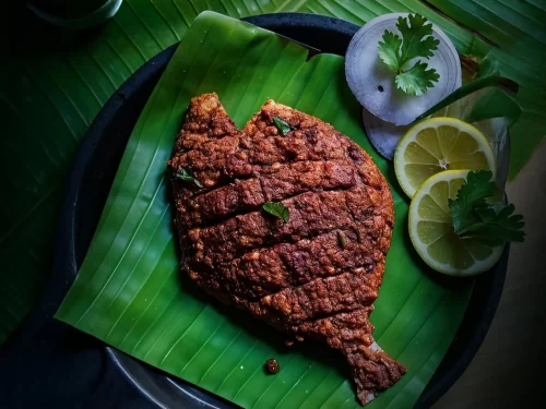 Houseboat at Alleppey backwaters during sunset, featuring palm trees and calm lagoons, romantic Kerala tour package.